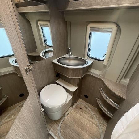 Kompaktes Wohnmobil-Badezimmer mit Waschbecken, Toilette und Stauraum