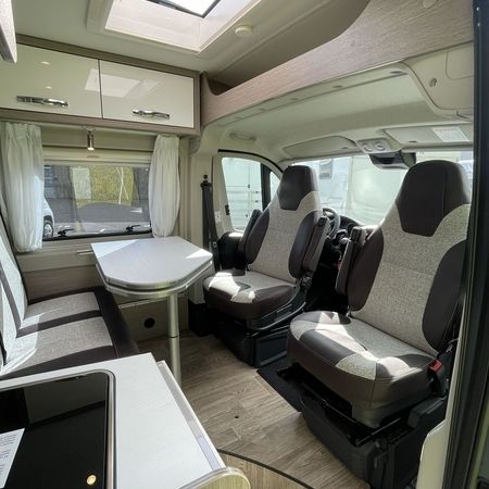 Indvendigt i en autocamper med kompakt køkken og hyggelig siddekrog