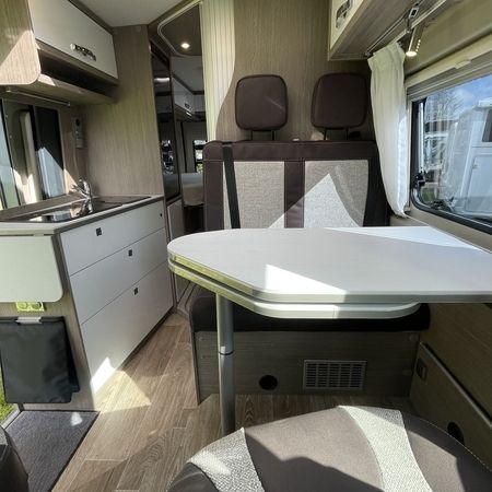 Indvendigt i en autocamper med hyggeligt bord og stole
