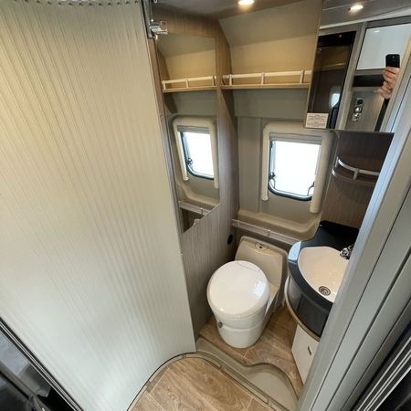 Et badeværelse med toilet, håndvask og bruser