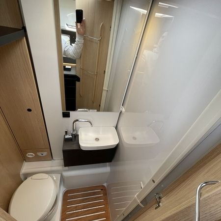 Kompakt badeværelse med moderne toilet, håndvask med elegant armatur