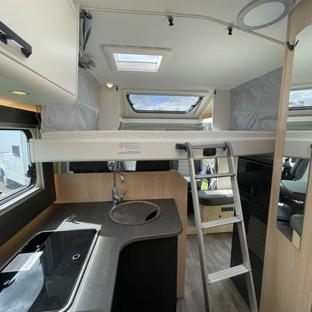 Indvendigt i en autocamper med håndvask og stige